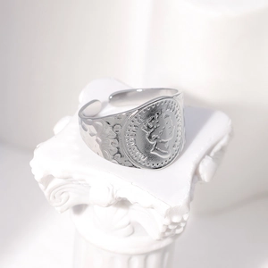 Detailed view of silver Elizabeth II coin relief and hammered band on adjustable ring
