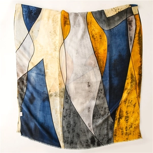 Close-up of geometric color block scarf featuring frayed edges and modern artistic patterns