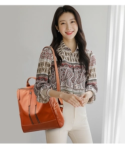 Brown PU leather backpack for women shown on a model with stylish vertical zippers