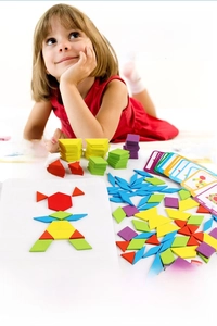 A child assembles a wooden geometric puzzle to create a girl figure with colorful blocks