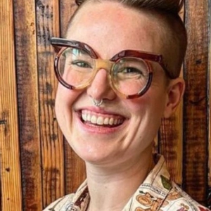 Close-up of stylish round tortoiseshell eyeglasses frame worn by a model in brown tones
