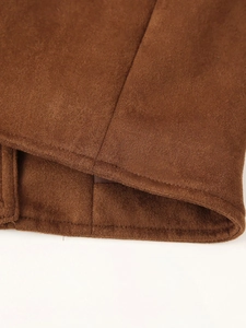 Vista detallada del dobladillo de la chaqueta de ante marrón con costuras precisas y finas