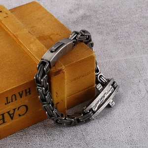 Detail of vintage silver cross pendant on a byzantine chain bracelet for men