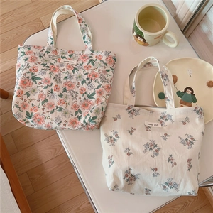 Detail of floral cotton handbags featuring vintage prints and woven logo labels