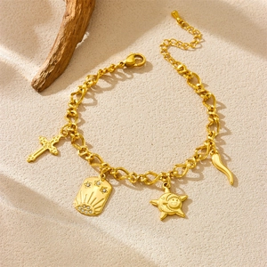 Gold plated stainless steel bracelet with cross, sun, and star pendants on natural wood base