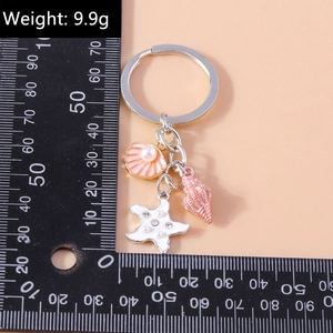 Detail view of pearl shell and starfish keychain charm with weight and size scale