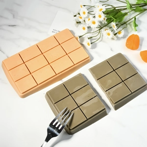 Molde de silicona de 12 rejillas para chocolate y pasteles en naranja y gris sobre mármol