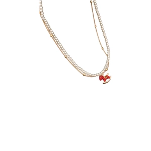 Elegant double-layered pearl necklace with a red rocking horse pendant and crystal accents