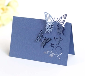 Detail of navy blue laser-cut butterfly place card with delicate floral patterns
