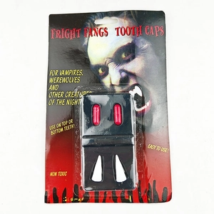 Close-up of Halloween vampire fangs set with edible red blood capsules in retail packaging