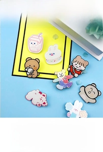 Close-up of cute acrylic cartoon brooches with rabbit and milk box patterns for bags