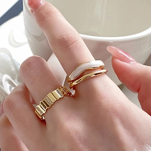 Close-up of gold cubic zirconia rectangular stackable rings on a model's hand