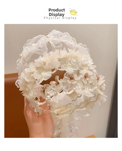 Detail of white lace headband with 3D floral petals and elegant pearl embellishments