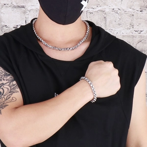 Close-up of a man wearing a silver stainless steel square pearl chain necklace and bracelet