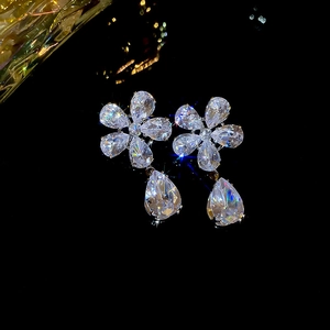 Detailed view of silver flower earrings with zircon pendants and sparkling crystal inlay