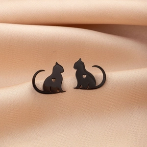 Close-up of minimalist black cat silhouette earrings with hollow heart detail on gold silk