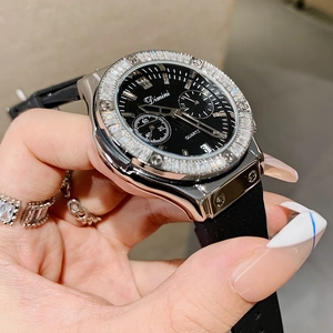 Elegant women's quartz watch with black rhinestone bezel and rubber strap on wrist