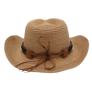 Detail of light brown straw cowboy hat with ethnic style ribbon and leather cord