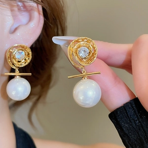 Detail of 14K gold plated pearl earrings with zircon swirl and white round pearls