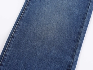 Macro view of blue denim jeans side seam featuring detailed double stitching craftsmanship