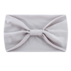 Detail shot of light grey knotted headband with soft, elastic texture for yoga and fitness