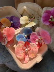 Macro view of artificial orchid hair clips with pearls in a natural eco-friendly box