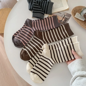 Detailed knit texture of striped crew socks in various colors on a white table