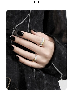 Close-up of dual-tone irregular S925 silver rings worn by a model in black