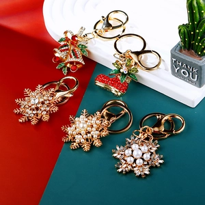 Detail of Christmas themed keychain charms with snowflakes, bells and rhinestones