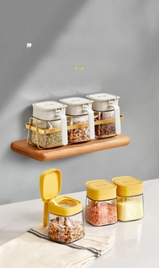 Detail of wall-mounted and countertop spice jar set with wooden shelf and gold metal rack