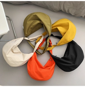 Top view of five colorful oxford fabric crescent crossbody bags with adjustable straps