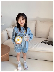 Toddler girl wearing light blue polka dot shirt with a yellow fried egg crossbody bag