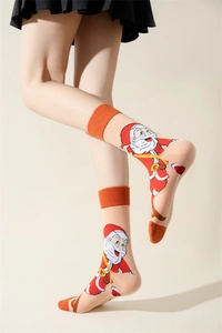 Detail of Christmas crew socks with Santa Claus pattern and orange ribbed cuffs on model