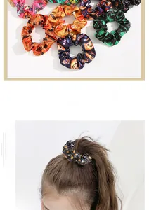 Detail of Halloween satin hair scrunchies with pumpkin bat and spider web patterns