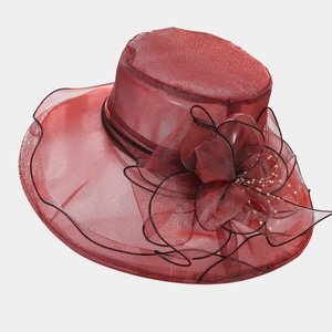 Détail d'un chapeau en organza bordeaux avec grande fleur et bordure noire élégante