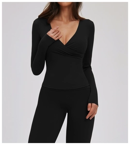 Detail shot of black long sleeve yoga top with V-neck cross design and slim fit fabric