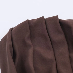 Detailaufnahme von dunkelbraunem gerafftem Stoff mit feiner Stricktextur und Falten