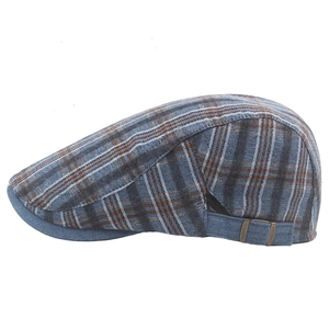 Detail of blue and brown plaid beret with woven texture and brass side buckle strap