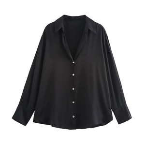 Detail of black satin long sleeve shirt featuring white pearl texture buttons and soft sheen