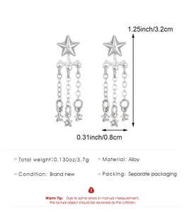 Détail de boucles d'oreilles étoiles argentées montrant la taille de 3,2 cm et le poids