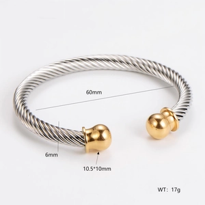 Detail view of two-tone cable twist bangle with golden ball ends and size dimensions