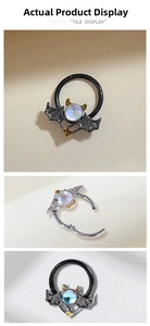 Macro shot of gothic bat wing body jewelry with iridescent stone in silver and black finish