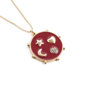 Golden necklace with red enamel pendant featuring gold stars, hearts and moon patterns