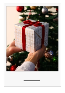 Close-up of elegant gift box with gold grid pattern and a bright red satin bow