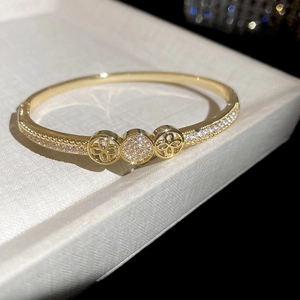 Close-up of 18K gold plated bangle featuring a sparkling zircon clover ring design