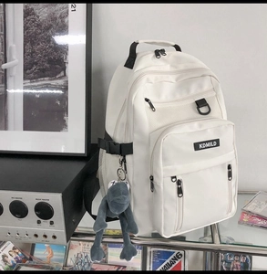 Dettaglio degli scomparti multistrato e tasche laterali a rete dello zaino in nylon bianco