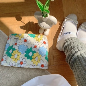 Detailed top view of floral cotton makeup bag on warm wood floor with natural shadows