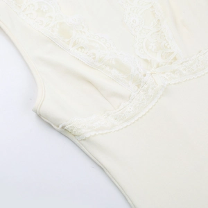 Detailed macro view of cream lace trim and bow knot on V-neck camisole top