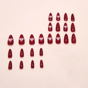 Almond shaped press-on nails in burgundy red with white hollow heart patterns