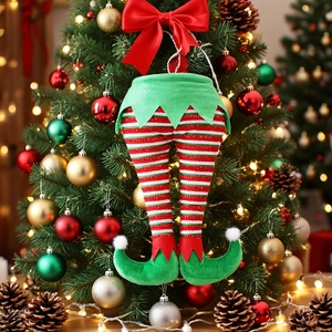 Plush Christmas elf leg ornament with red and green stripes hanging on a decorated tree